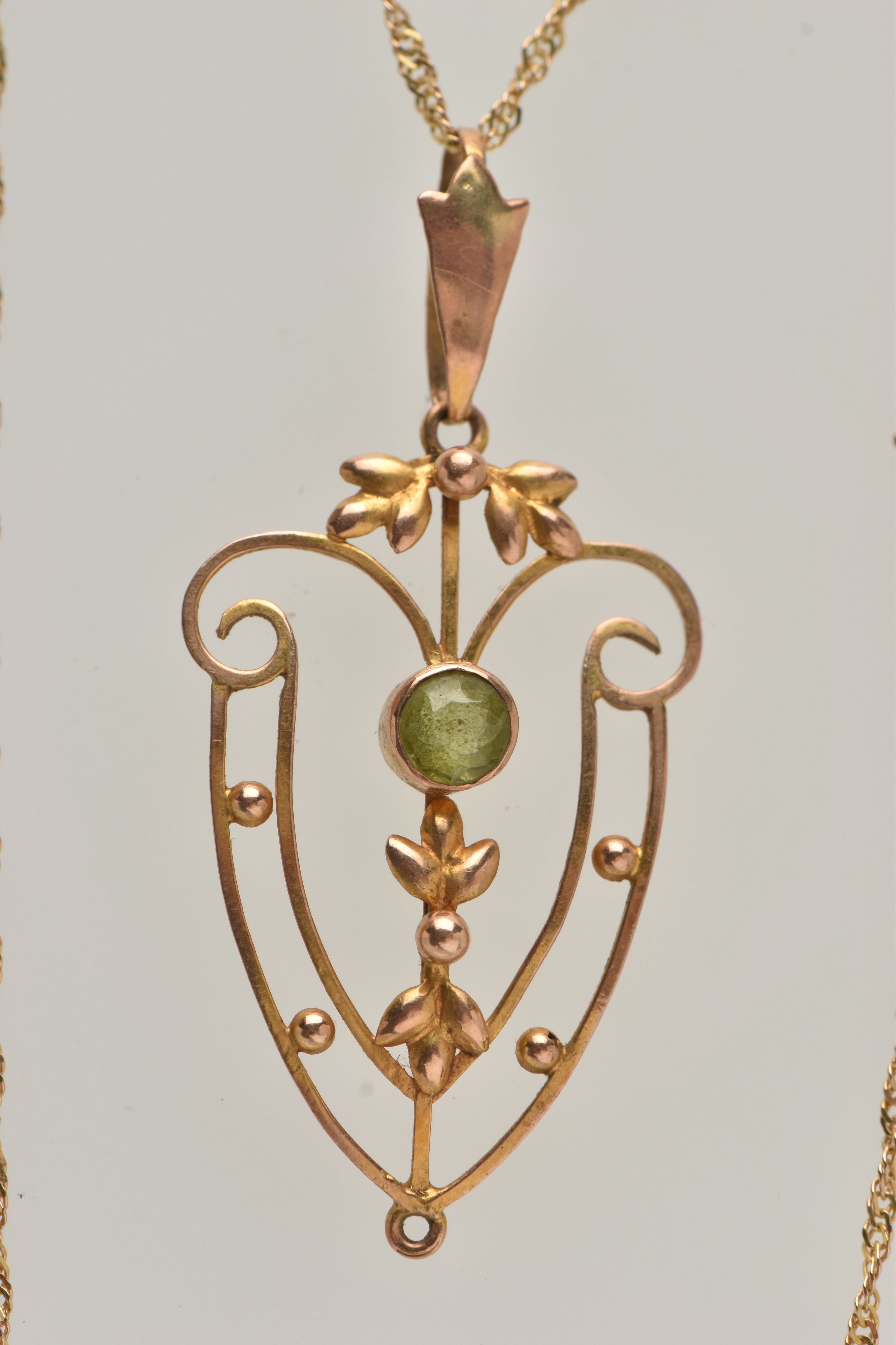 AN EDWARDIAN PENDANT AND CHAIN, open work floral pendant, set with a circular cut peridot, missing - Image 2 of 4