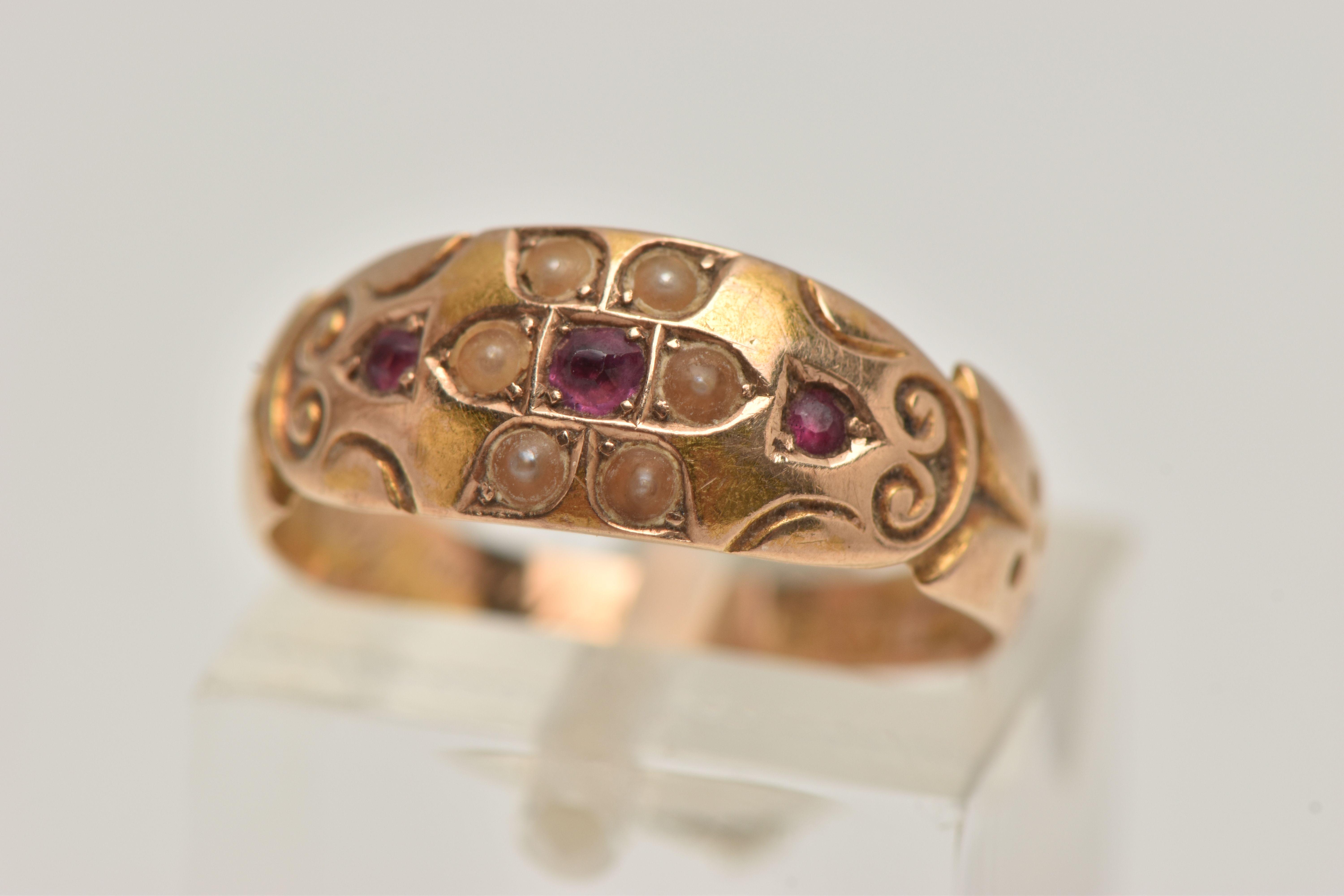 A LATE VICTORIAN 15CT GOLD RUBY AND PEARL RING, flower detail to the centre set with a central