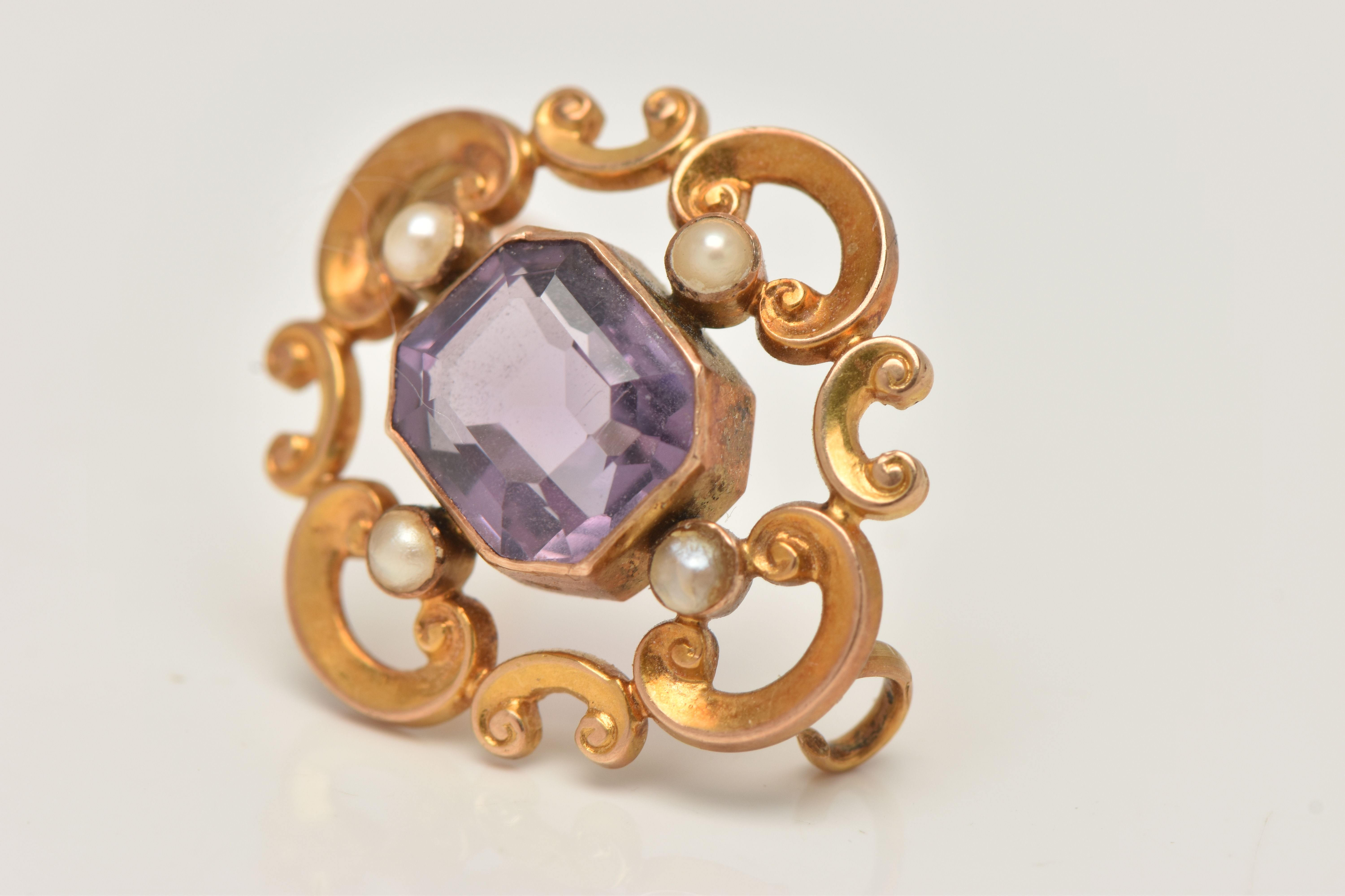 A YELLOW METAL AMETHYST AND SEED PEARL BROOCH, open work scrolling brooch set with a central emerald - Image 3 of 4