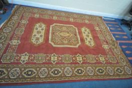 A LARGE WOOLLEN FLORAL RED AND GOLD RUG, 338cm x 247cm, and a blue wool carpet runner (condition