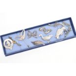 A SELECTION OF SILVER AND WHITE METAL JEWELLERY, to include mainly brooches, two designed as