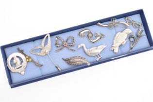A SELECTION OF SILVER AND WHITE METAL JEWELLERY, to include mainly brooches, two designed as