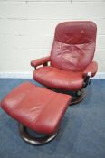 AN EKORNES STRESSLESS RED LEATHER RECLINING SWIVEL ARMCHAIR, and a footstool (condition report:
