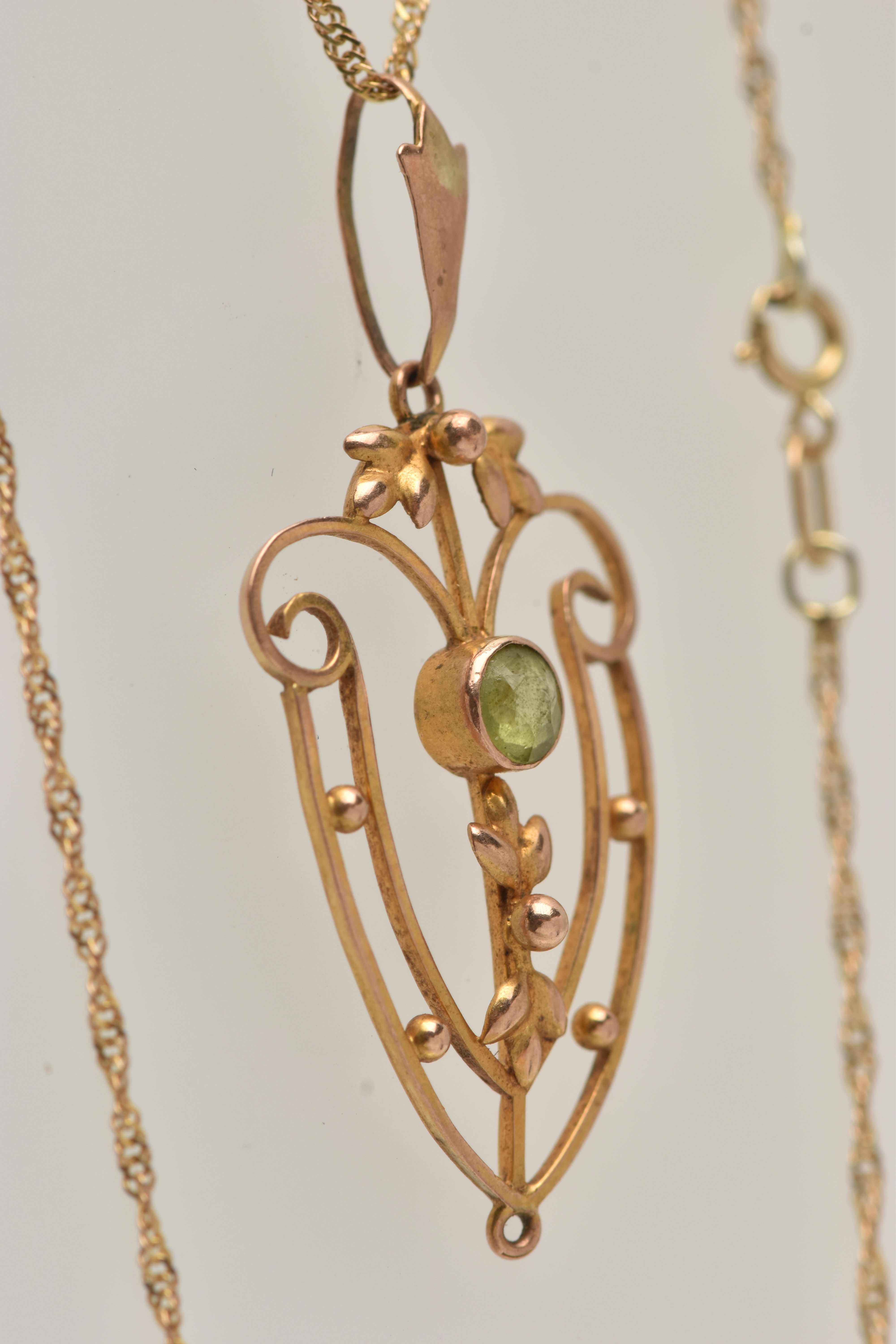 AN EDWARDIAN PENDANT AND CHAIN, open work floral pendant, set with a circular cut peridot, missing - Image 3 of 4