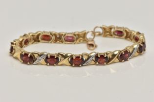 A 9CT GOLD AND GARNET BRACELET, twelve oval cut garnets, prong set in yellow metal, interspaced