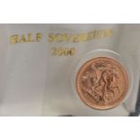 A HALF SOVEREIGN COIN, 2000 George and the Dragon, Elizabeth II, encased in plastic casing