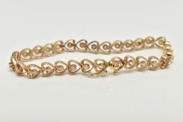 A YELLOW METAL AND DIAMOND BRACELET, heart link bracelet, each link set with a round brilliant cut