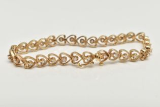 A YELLOW METAL AND DIAMOND BRACELET, heart link bracelet, each link set with a round brilliant cut