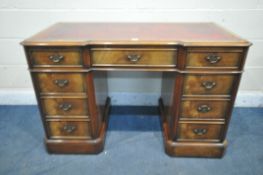 A CHARLES BARR MAHOGANY KNEE HOLE DESK, with a red leather writing surface, and nine drawers,