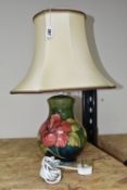 A MOORCROFT POTTERY 'HIBISCUS' TABLE LAMP, decorated with red and yellow Hibiscus on a green ground,