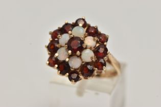 A 9CT GOLD GARNET AND OPAL CLUSTER DRESS RING, comprised of thirteen circular cut garnets and six