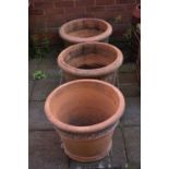 A PAIR OF CYLINDRICAL TAPERED TERRACOTTA PLANTERS, diameter 56cm x height 41cm along with another