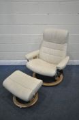 AN EKORNES STRESSLESS CREAM LEATHER RECLINING SWIVEL ARMCHAIR, with footstool (condition report: