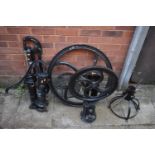 A SELECTION OF CAST IRON ITEMS, to include two pumps, a loose wheel, a wheel on stand labelled '
