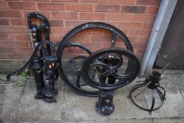 A SELECTION OF CAST IRON ITEMS, to include two pumps, a loose wheel, a wheel on stand labelled '