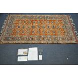 A TURKISH WOOL PATTERNED RUG, orange field within a repeating pattern, and a multi strap border,