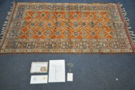 A TURKISH WOOL PATTERNED RUG, orange field within a repeating pattern, and a multi strap border,