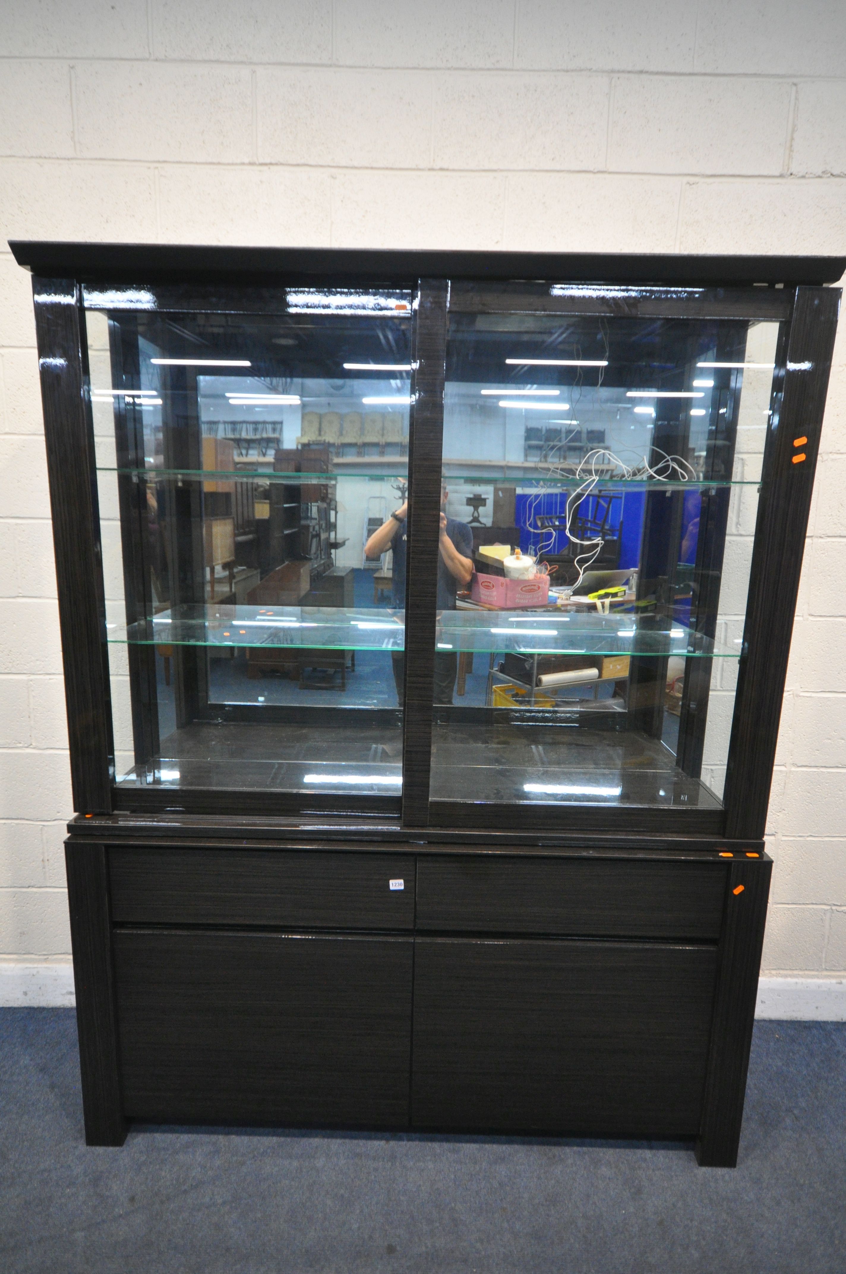 A BLACK FINISH GLAZED DISPLAY CABINET, with sliding doors, enclosing two glass shelves, over a - Image 2 of 3