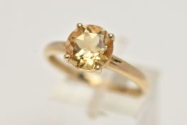 A 9CT GOLD CITRINE RING, the circular cut Citrine within a four claw setting to the plain band, with