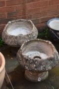 A PAIR OF COMPOSITE GARDEN URNS, with a circular top, on a separate tapered base, with foliate