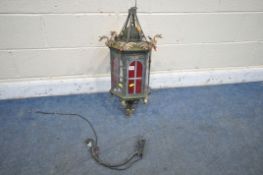 A METAL HEXAGONAL WALL HANGING LANTERN, depicting dragon heads to each top corner, red stained glass
