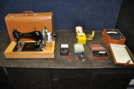 A LEATHER CASED MANUAL SINGER SEWING MACHINE, serial number 15 040 687, an Avometer 8 in original