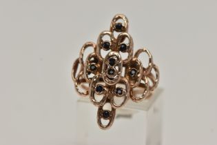 A 9CT GOLD ABSTRACT RING, rose gold open work design, textured detail set with ten circular cut
