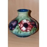 A MOORCROFT POTTERY SQUAT BALUSTER VASE DECORATED WITH PINK AND PURPLE ANEMONES ON A GREEN / BLUE