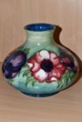 A MOORCROFT POTTERY SQUAT BALUSTER VASE DECORATED WITH PINK AND PURPLE ANEMONES ON A GREEN / BLUE