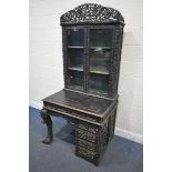 A 19TH CENTURY EBONISED ROSEWOOD CHINESE BOOKCASE ABOVE DESK, heavily carved throughout with