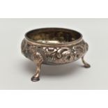 A VICTORIAN SILVER CIRCULAR OPEN SALT, repoussé decorated with flowers and scrolls, on three