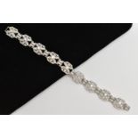 AN ART DECO STYLE DIAMOND BRACELET, nine white metal panels, each set with a single bezel set