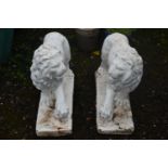 AN OPPOSING PAIR OF WHITE PAINTED COMPOSITE LIONS, with turned heads, and one front foot raised,