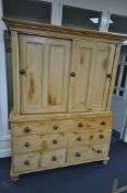 A 19TH CENTURY PINE HOUSEKEEPERS CUPBOARD, overhanging cornice, double panelled sliding doors
