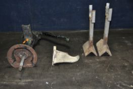 A VINTAGE CAST IRON PUMP, two bespoke metal stands, and a cast metal wall hanging item, labelled 7
