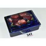 A MOORCROFT POTTERY RECTANGULAR LIDDED TRINKET BOX, 'Anemone' pattern on a dark blue ground, paper