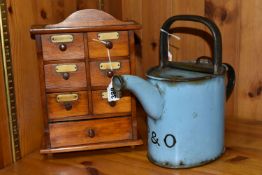 A SMALL SPICE CABINET AND A BLUE ENAMEL HOT WATER POT, comprising a seven drawer spice cabinet,