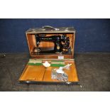 A VINTAGE CASED SINGER SEWING MACHINE in alligator skin style case with a quantity of accessories