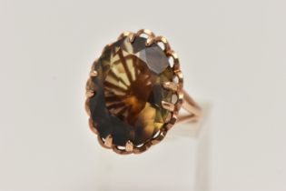 A LARGE 9CT GOLD SMOKY QUARTZ DRESS RING, oval cut smoky quartz, double claw set within an open work