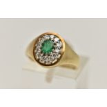 A 14CT GOLD GEM SET RING, a signet style cluster ring, oval cut emerald, prong set with a surround