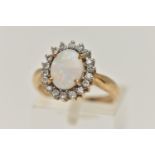 A 9CT GOLD OPAL AND DIAMOND CLUSTER RING, oval opal prong set with a surround of eighteen round