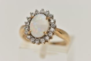 A 9CT GOLD OPAL AND DIAMOND CLUSTER RING, oval opal prong set with a surround of eighteen round