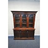 A VICTORIAN STYLE MAHOGANY GLAZED THREE DOOR BOOKCASE, over a base with three drawers and cupboard