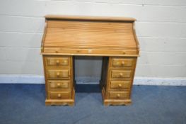 A MODERN PINE TWIN PEDESTAL ROLL TOP DESK, with a fitted interior, each pedestal with four