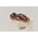 A YELLOW METAL GEM SET VICTORIAN RING, set with two oval cut amethysts and circular cut emerald