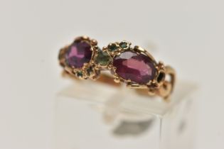 A YELLOW METAL GEM SET VICTORIAN RING, set with two oval cut amethysts and circular cut emerald