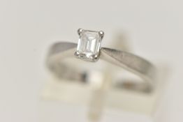 A PLATINUM SINGLE STONE DIAMOND RING, emerald cut diamond prong set in platinum, leading on to a