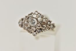 A WHITE METAL ABSTRACT DIAMOND RING, raised marquise shape, set with a central round brilliant cut