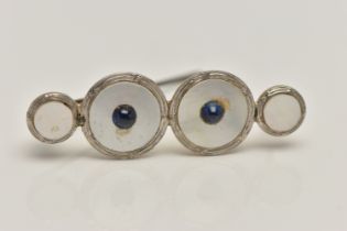 A CONVERSION BROOCH, four mother of pearl white and yellow metal dress studs fitted together, fitted