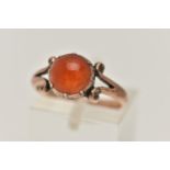 A ROSE METAL CARNELIAN RING, set with a circular cut carnelian cabochon, claw set, bifurcated scroll